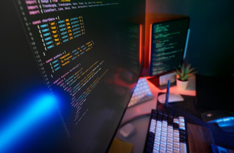A vibrant workspace featuring colorful code on computer monitors, ideal for developers.